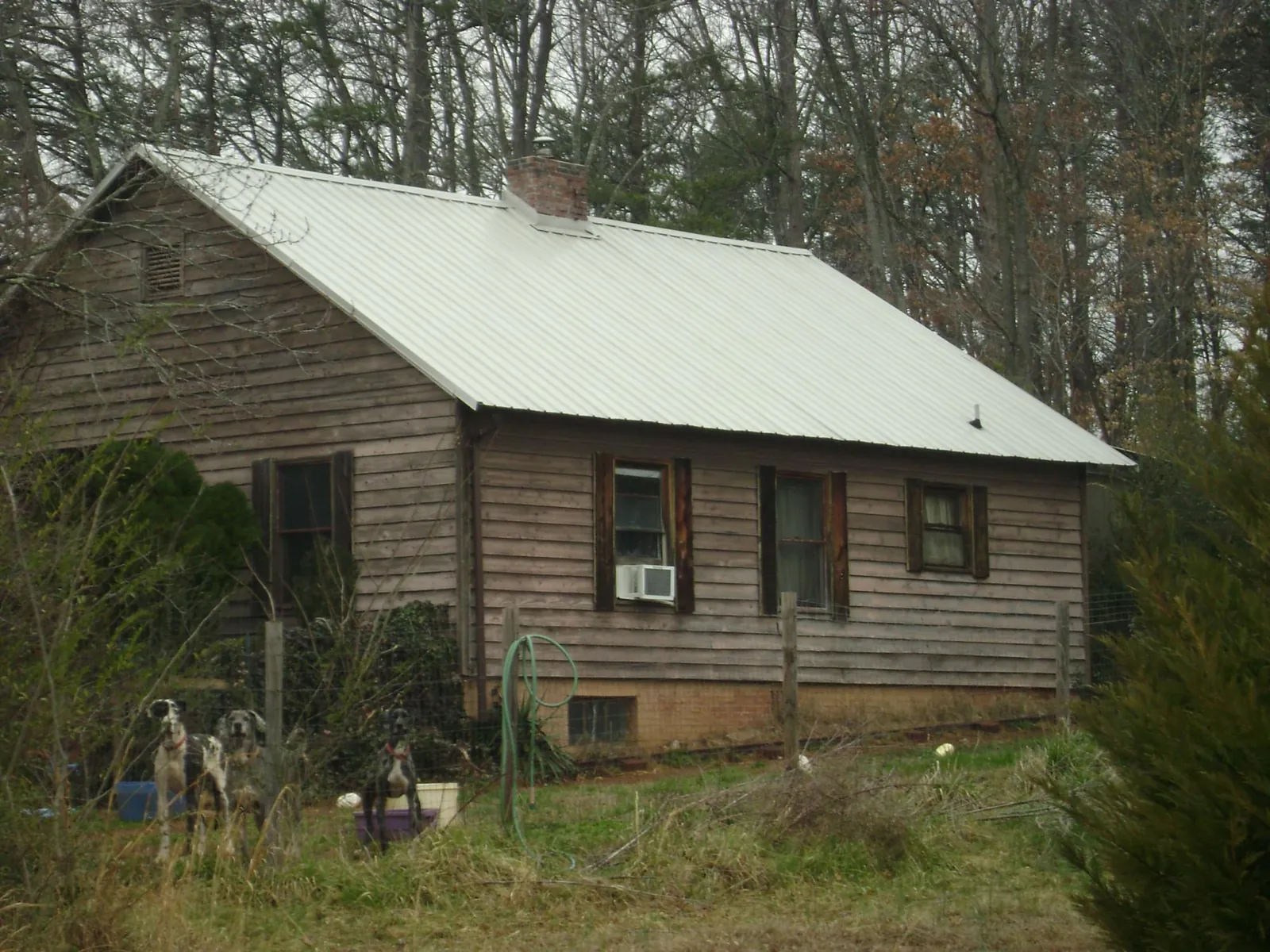White metal roof on an old wood sided farmhouse, from a Asphalt Shingle Roof Repair job in Lawton